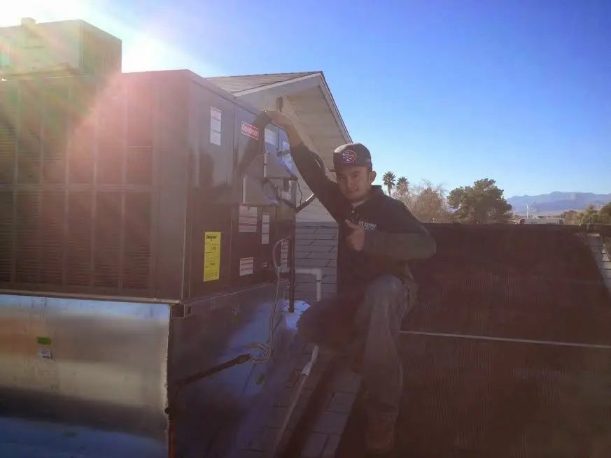 HVAC technician performing AC Tune-Up on a rooftop unit in Corning
